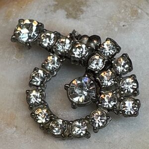 Vintage AJC rhinestone brooch in a tidal wave design.